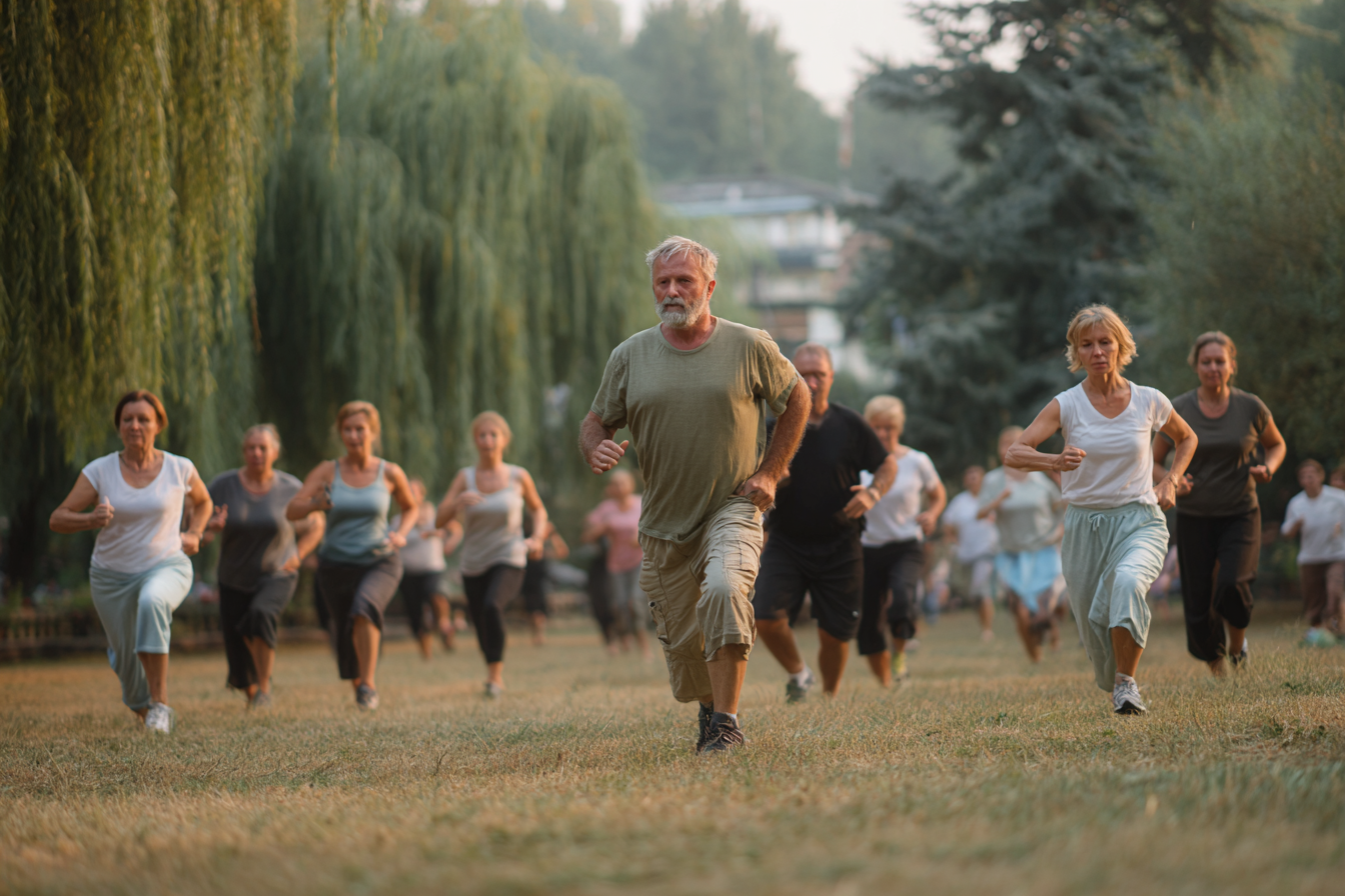 Група старших людей займається фітнесом на природі